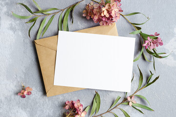 Invitation or greeting card mockup with envelope and flowers plants decorations.