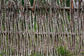 Old wooden rustic fence made of willow branches