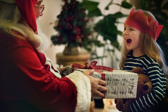Santa Claus giving out a gift to a little girl