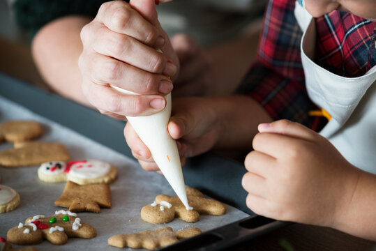 Boy making gingerbread cookies with his mum