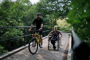 Couple exercising together on a bicycle and in a wheelchair