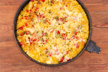Casserole with pasta and vegetables in old pan, top view