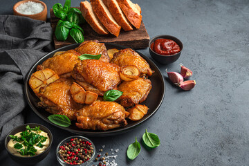Lunch with fried chicken thighs on a dark graphite background. Side view, copy space.