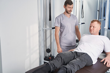 Fototapeta na wymiar Rehabilitating patient with sports injury on massage table