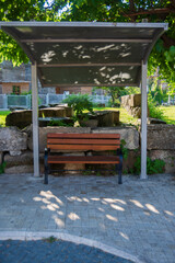 An empty bench under the shadows on a summer day. A bus stop in Side Antalya. Selective Focus. Space for Copy