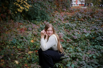 Cute girl sitting in the garden with closed eyes