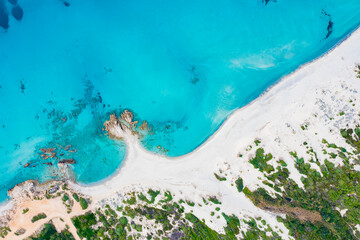 View from above, stunning aerial view of a white sand beach bathed by a turquoise water. Rena Majore, Sardinia, Italy.
