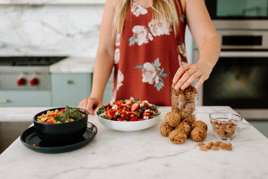 Female nutrient filling cookie in jar at kitchen counter