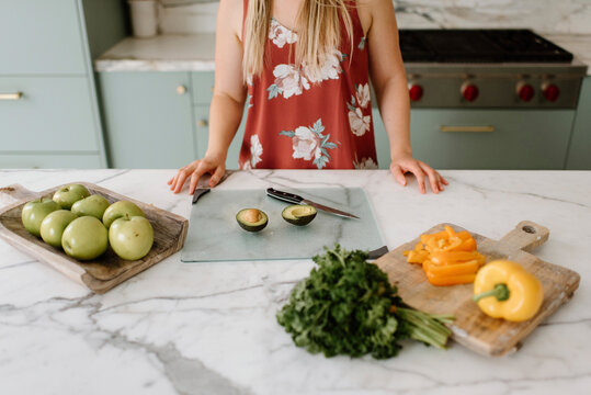 Female nutrient coach with vegetables and fruits at kitchen counter