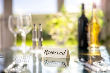 Restaurant reserved table sign with place setting and wine glasses ready for party - obrazy, fototapety, plakaty