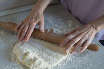 Yeast dough for bread or pizza on a floured surface, with flour splash. Cooking bread. Kneading the Dough.
the process of making dough