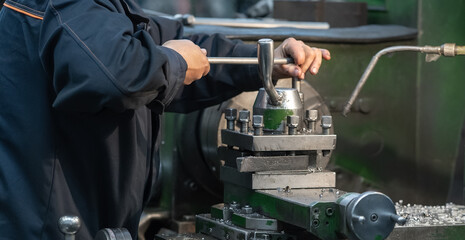 Female worker hands at machine tool for working with metal production close up.