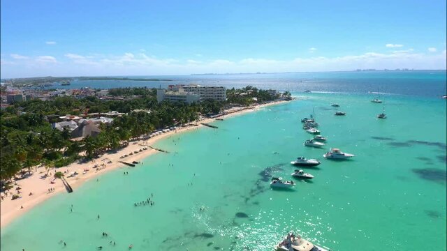 Drone video of Playa Norte or North Beach on the island of Isla Mujeres, Mexico. A beautiful beach with white sand and shiny turquoise water around it
