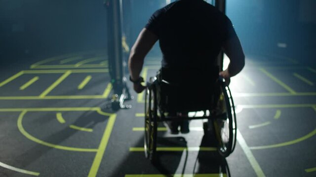 Motivation, disabled athlete in wheelchair performs pull-ups on the horizontal bar, gym training and physical activity, people with disabilities, 4k slow motion.
