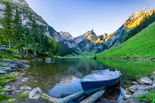 Rowboat left on scenic shore of Seealpsee lake at dawn