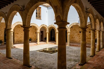arcaded cloister of the convent or monastery with stone columns and a water fountain in the center