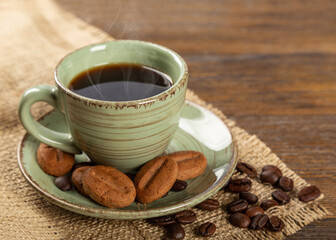 Cup of coffee and cookies on a wooden background