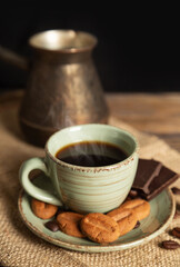 Cup of hot black coffee and cookies