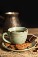 Cup of hot black coffee and chocolate