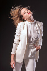 Fashion studio portrait of a beautiful woman with a long brown hair. Young model with beautiful hair - black background vertical. Girl with reddish hair flying in the wind. Blurred details.