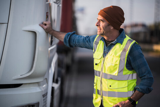 Male driver standing by truck at commercial dock