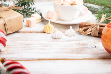 Christmas or New Year composition. Decorations, box, balls, fir and spruce branches, cup of coffee, on a white wooden background. Side view, copy space, selective focus.
