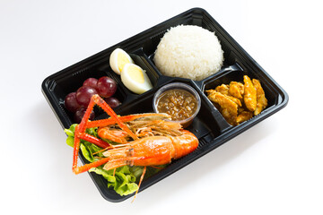 Thai food lunch box in plastic packages, Rice with fried shrimp and red chicken curry.