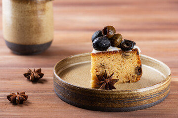 A piece of cake with green and black olives and lemon on a plate. Sugar, gluten and lactose free, vegan.