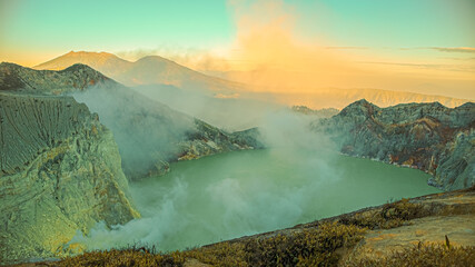 beautiful panoramic view of ijen crater at sunrise. sulfur fog billows over the turquoise lake into the air. kawah Ijen volcano, East Java, Indonesia.