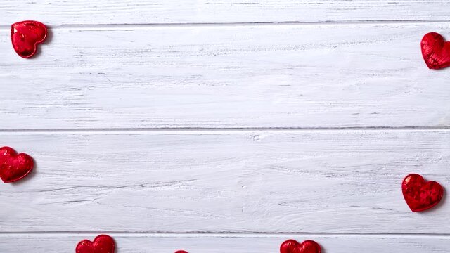 Valentines day background with red hearts, stop motion animation with copy space, frame. Love hearts on the white wooden background