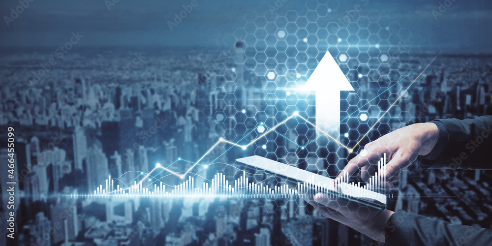Poster close up of businessman hand using tablet with creative glowing arrow with business chart on blurry 