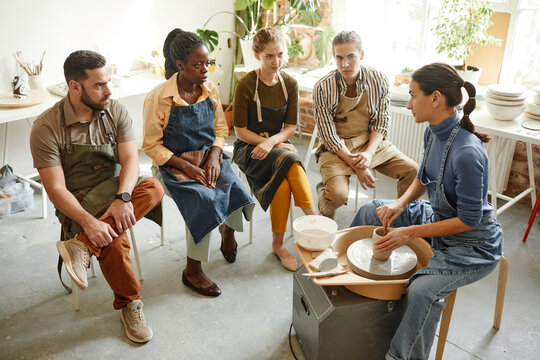 Full length view at diverse group of people at pottery workshop in cozy studio, copy space