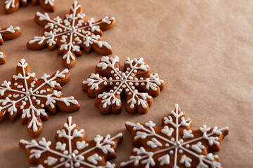 Christmas background with homemade snowflake shape gingerbread cookies on biege background. New Year celebration traditions concept.