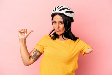 Young caucasian woman with one arm wearing a bike helmet isolated on pink background feels proud and self confident, example to follow.