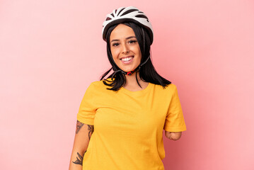 Young caucasian woman with one arm wearing a bike helmet isolated on pink background happy, smiling and cheerful.
