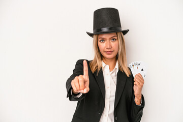 Young caucasian wizard woman holding magic card isolated on white background showing number one with finger.
