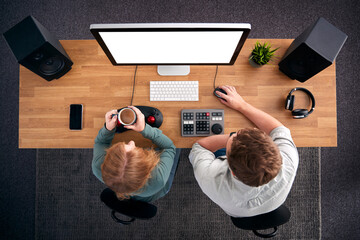 Overhead View Of Male And Female Video Editors Working At Computer In Creative Office