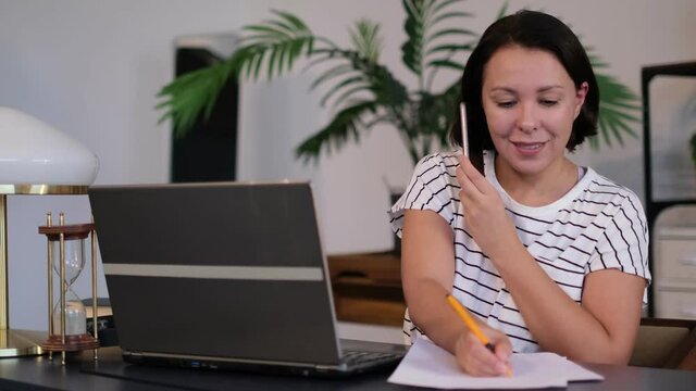 woman calling her friend, talking and asking about something, using laptop. freelancer talks to a customer, or an employee negotiates with a client