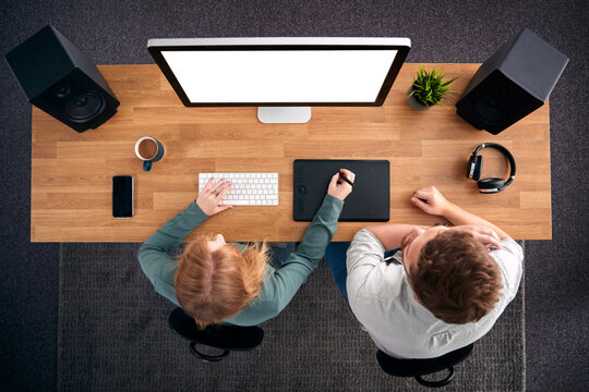 Overhead View Of Male And Female Graphic Designers Working At Computer In Creative Office