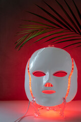 Color therapy mask glowing red, palm leaf