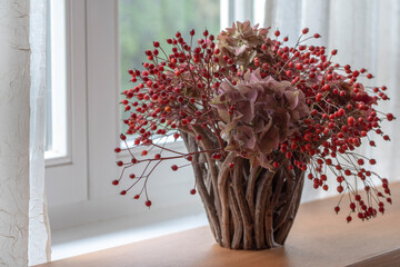 Autumn flower arrangement in basket, window sill