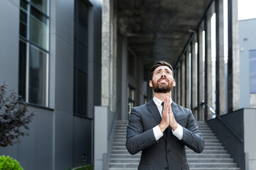Portrait young bearded businessman begs God for success With Hope raising his hands up to sky. business man asks for luck and prays for a successful solution Asking For Help.