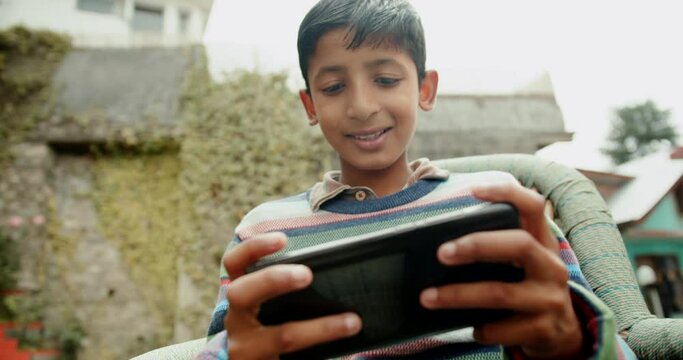 A 4K Of A South Asian Boy Playing A Game With Mobile. Shimla, Himachal Pradesh, India