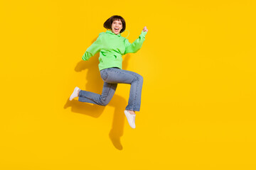 Fototapeta na wymiar Full length body size view of attractive amazed cheerful girl jumping running isolated over bright yellow color background