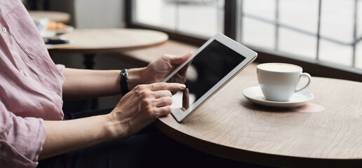 Young woman using digital tablet in cafe panoramic banner. Female hands holding digital tablet close up.  Coffee break, modern lifestyle, connection, technology, business, online shopping concept