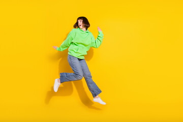 Full length photo of cheerful nice attractive woman jump up look empty space isolated on yellow color background