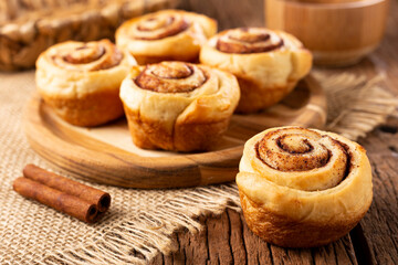 Cinnamon rolls on wooden background.