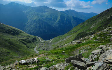 Transfagarasan road winding along an alpine grassland near rocky mountain ridges and mountain...