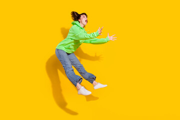 Fototapeta na wymiar Full length body size view of lovely amazed girl jumping catching copy space isolated over bright yellow color background