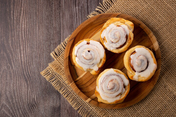 Cinnamon rolls on wooden background.
